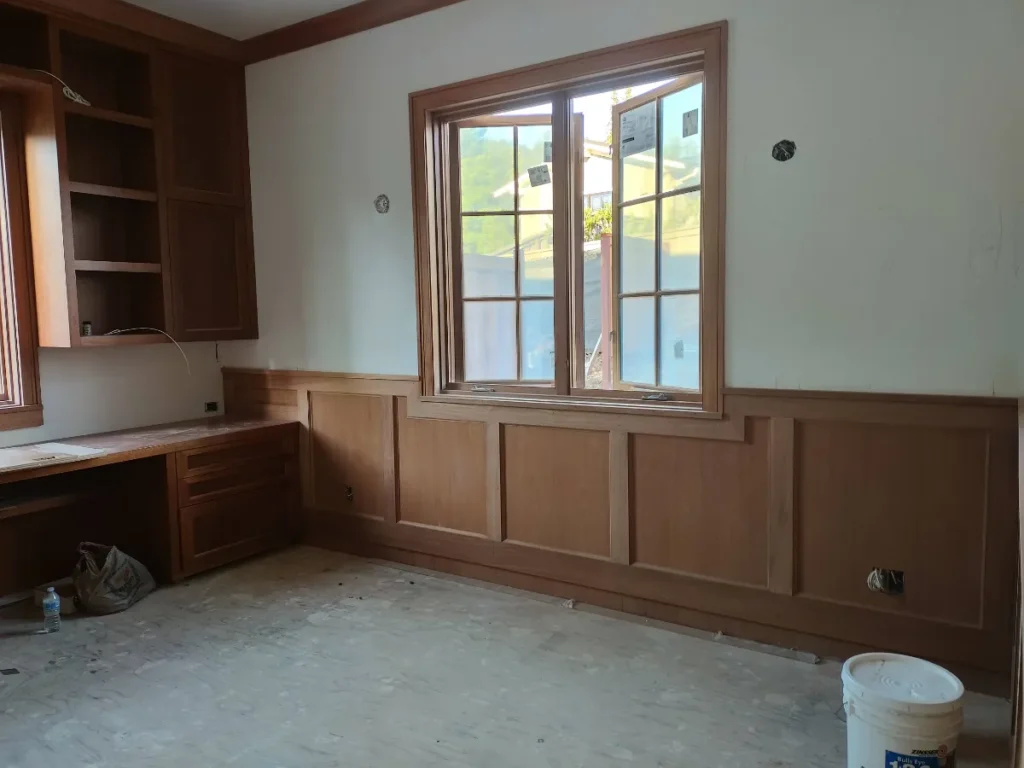 Elegant wooden paneling beneath large windows.