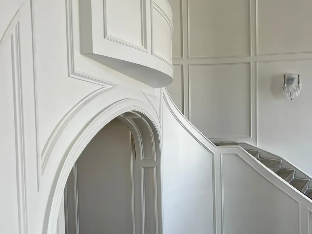 Elegant staircase with arched wall details.