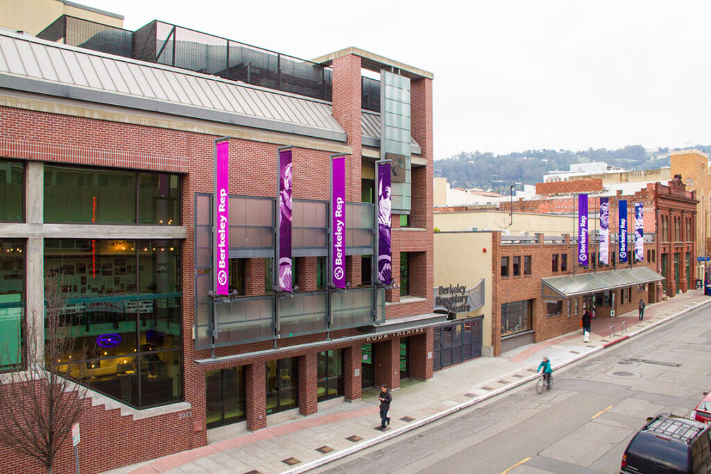 Modern building with purple banners on a city street.