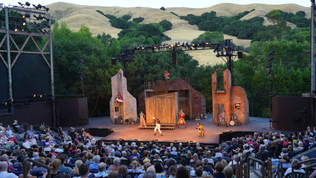 Outdoor amphitheater with a performance and an audience.