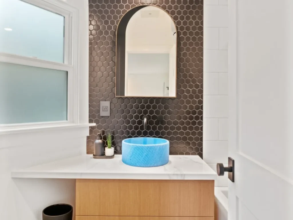 A modern bathroom with blue sink design.