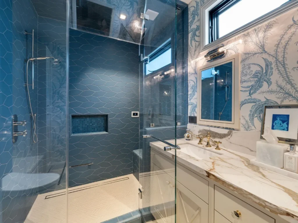 Shower area with blue tiles and glass enclosure.