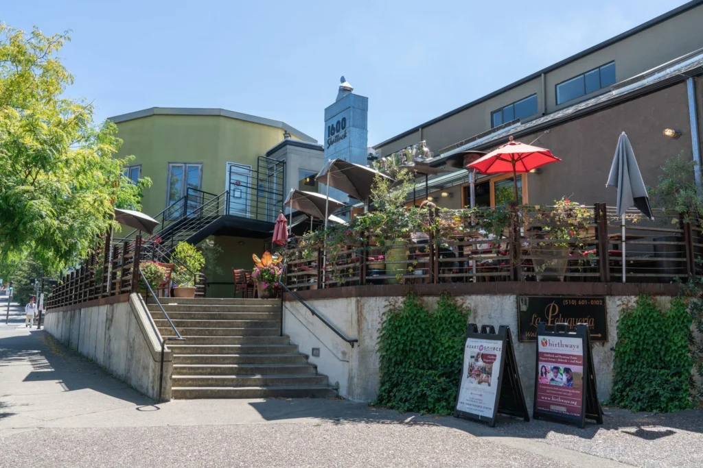 Restaurant entrance with outdoor seating and umbrellas.