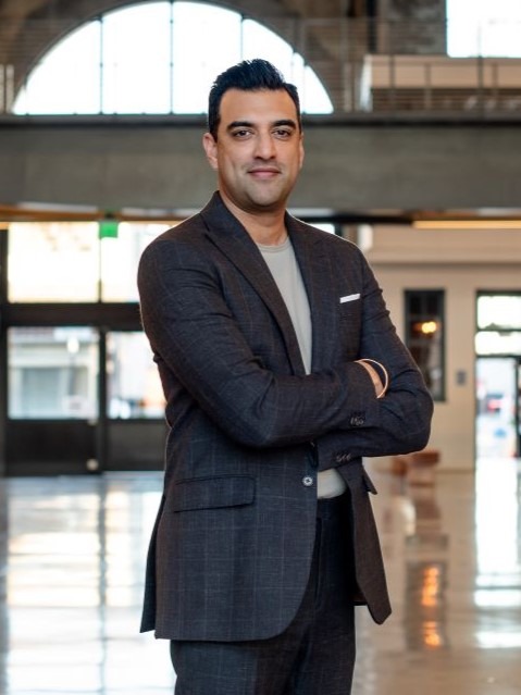 Two men standing, arms crossed, outside.