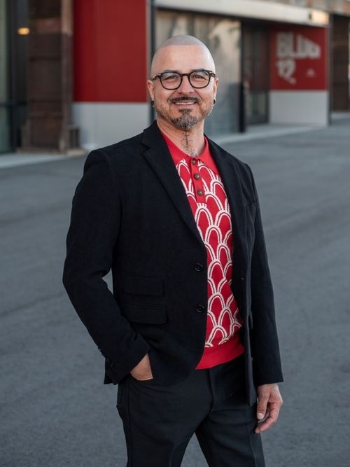 Man in black suit and red sweater