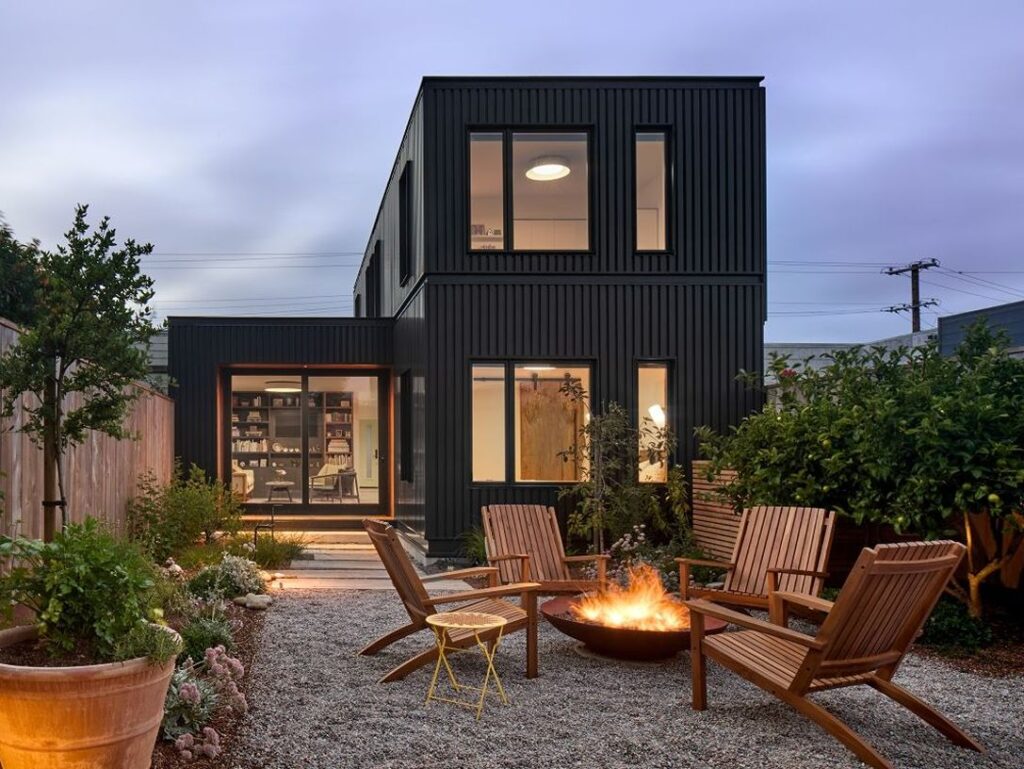 Modern black house exterior with fire pit