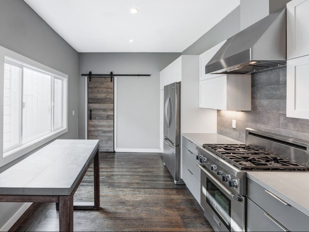 Kitchen with white cabinets and dark floors.