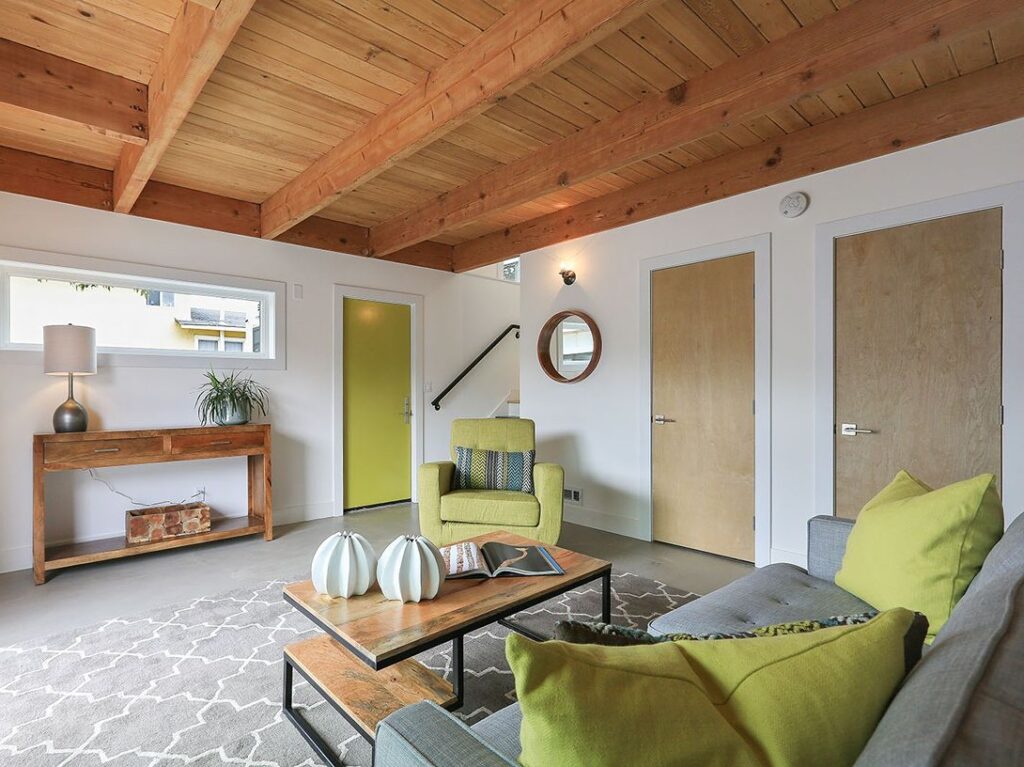 Living room with wood ceiling and green couch.