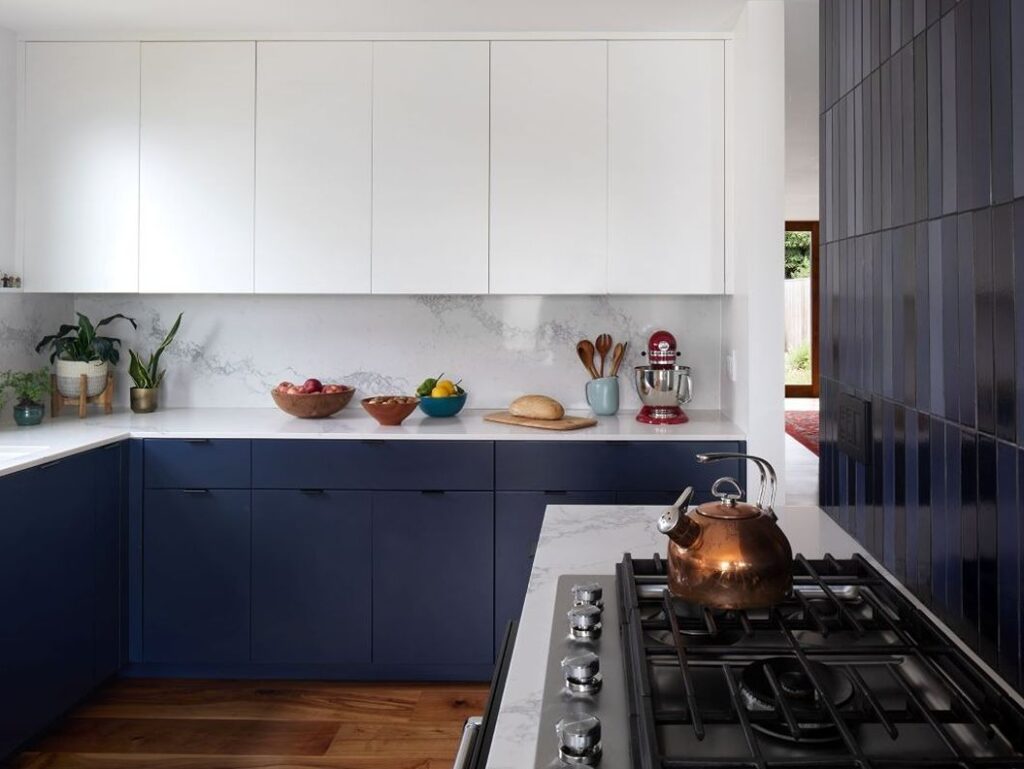 Contemporary kitchen with white cabinets and navy accents.