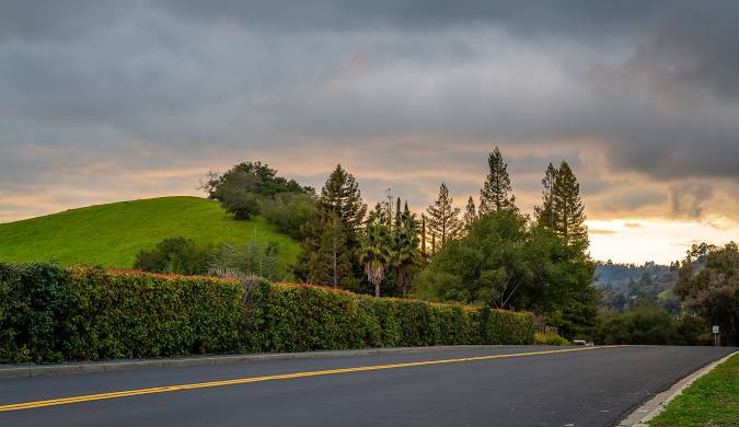 Cloudy skies over rolling green hills.