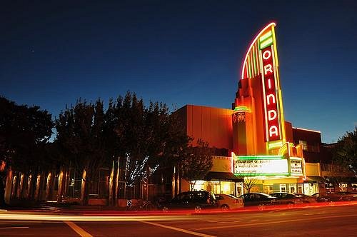 A brightly lit cinema at night with neon signage.