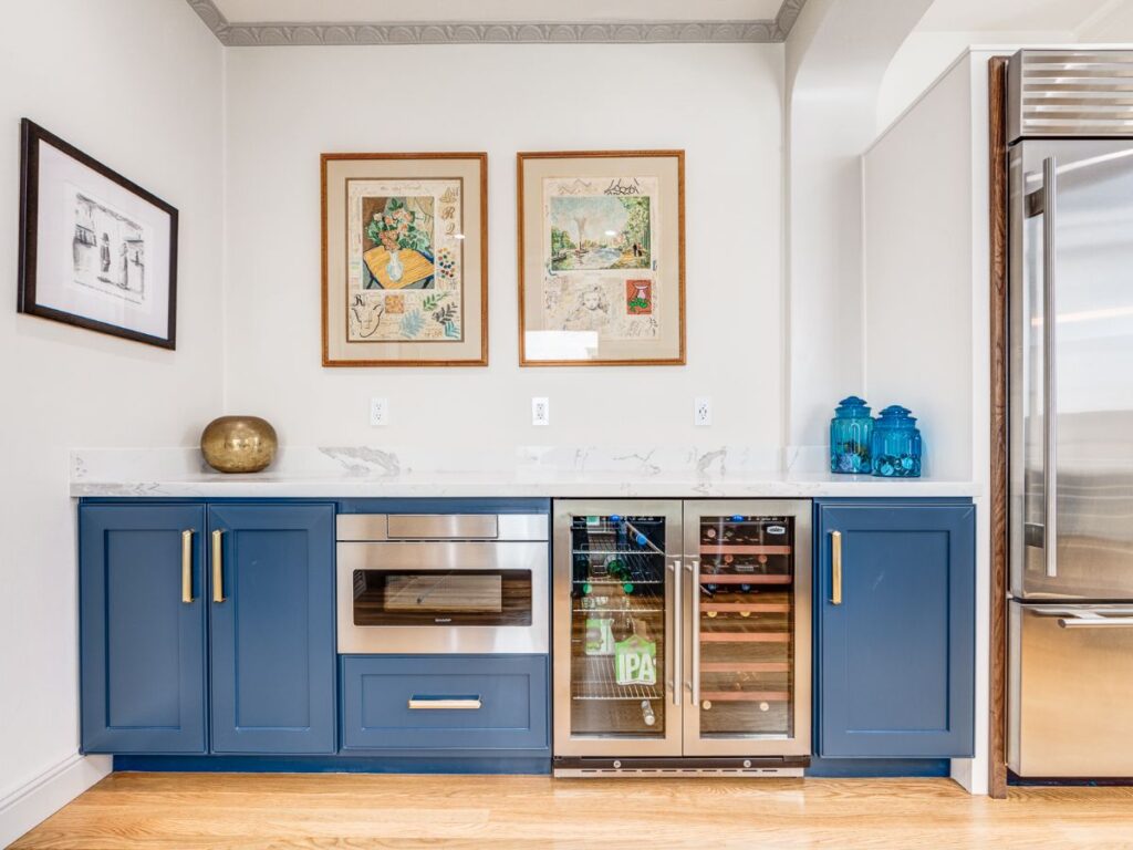 Blue beverage center with artwork in a bright room.