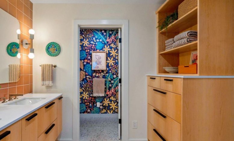 Wooden hallway with bright floral wallpaper in doorway.